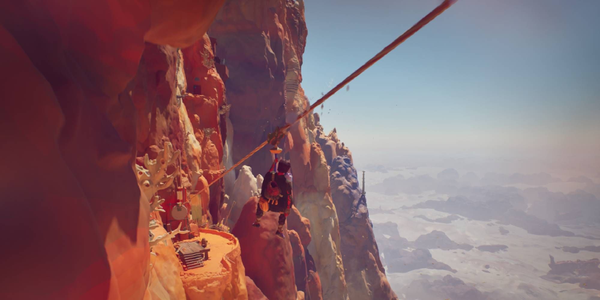 jusant main character riding zip wire alongside cliffside village.