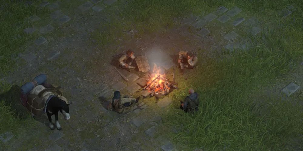 The party sitting around campfire in Wartales.