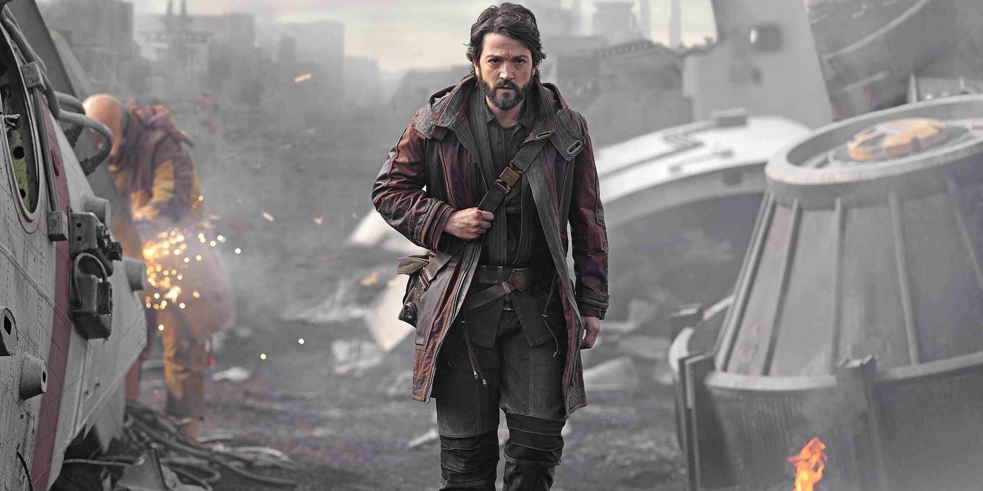 Cassian walking through the Ferrix shipyard in Andor.