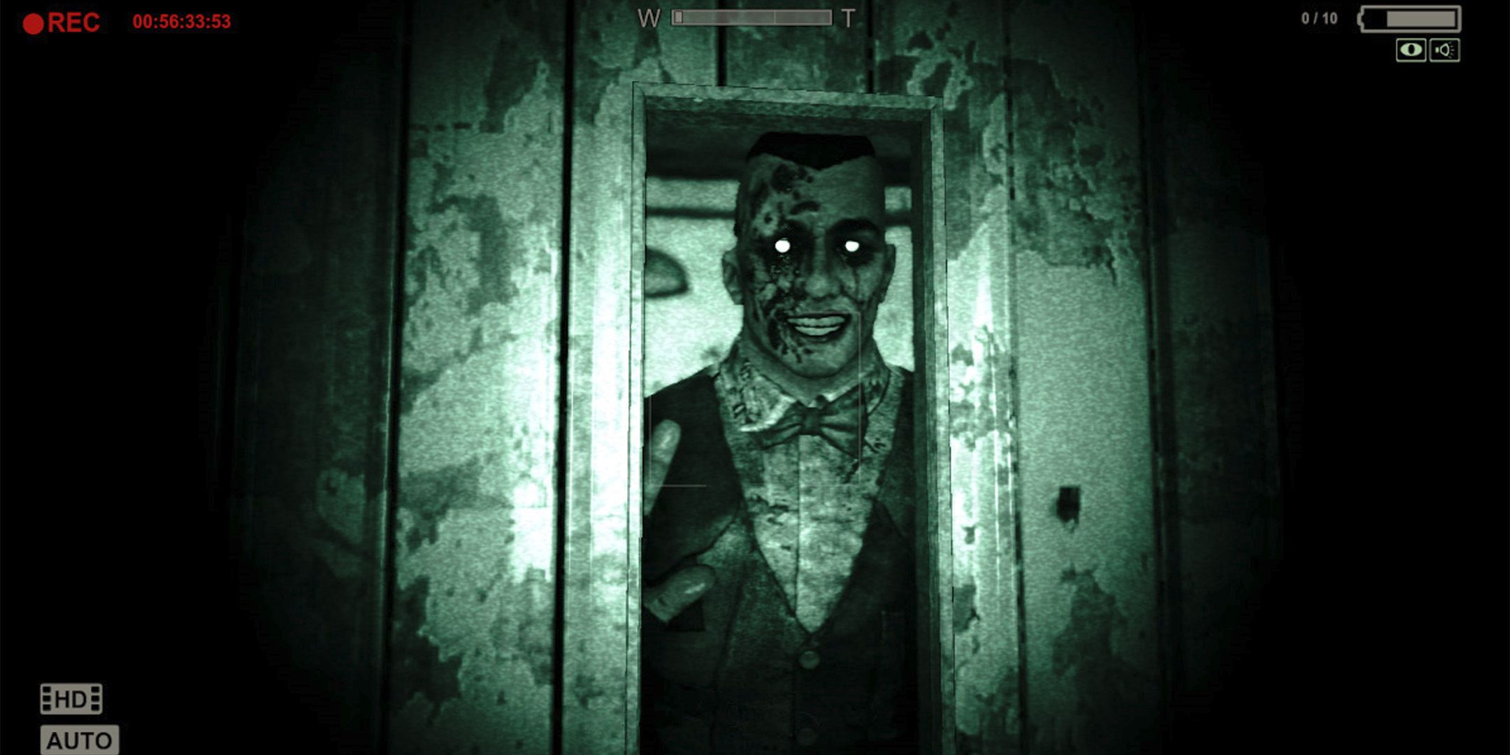 A scary man in a tuxedo standing in a dark room from Outlast.