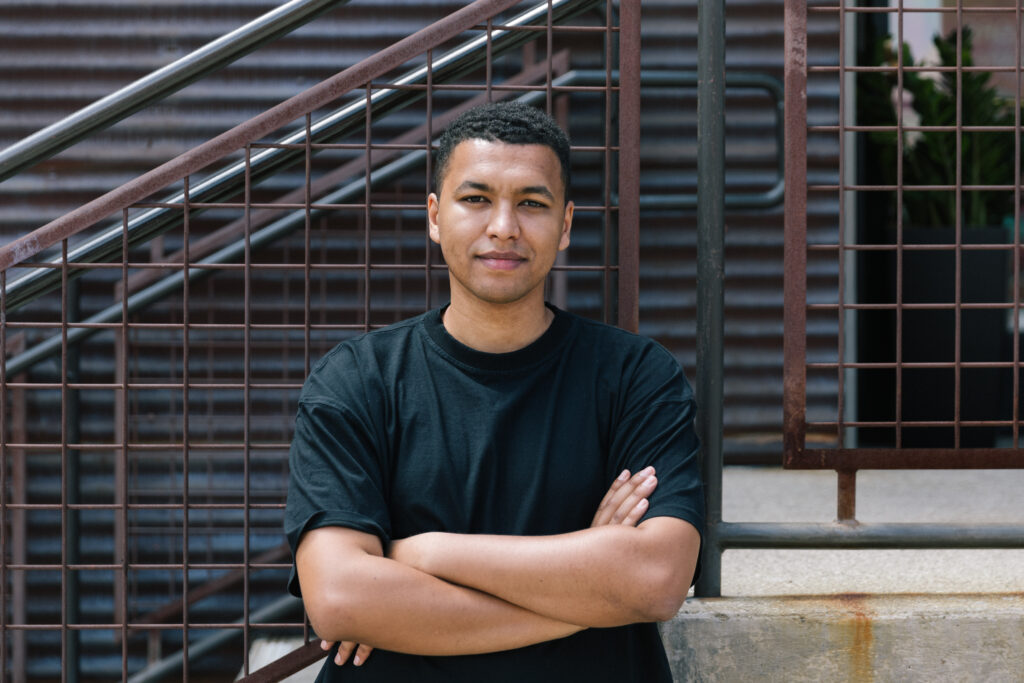 Photo of man with his arms crossed, smiling slightly