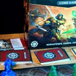 Warhammer Underworlds: Embergard box, cards, tokens, models, and board on a wooden table