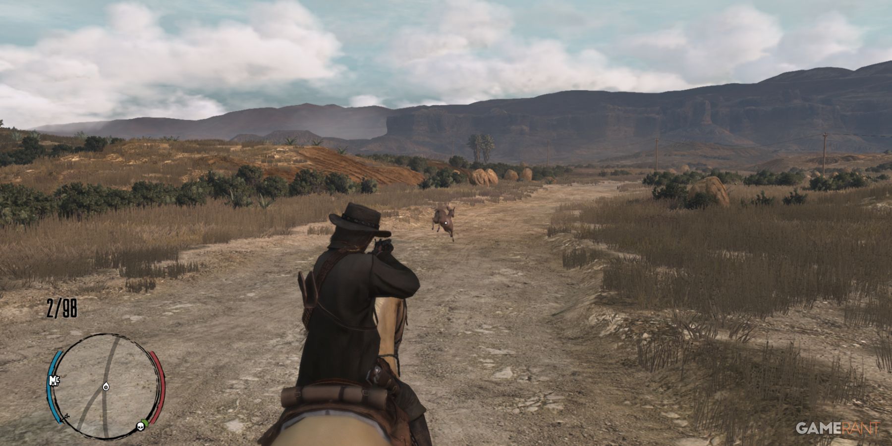 Character on horseback aiming at a deer running down a dirt road in Red Dead Redemption