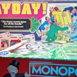 A collection of board games stacked together, with Paypay and Monopoly clearly visible