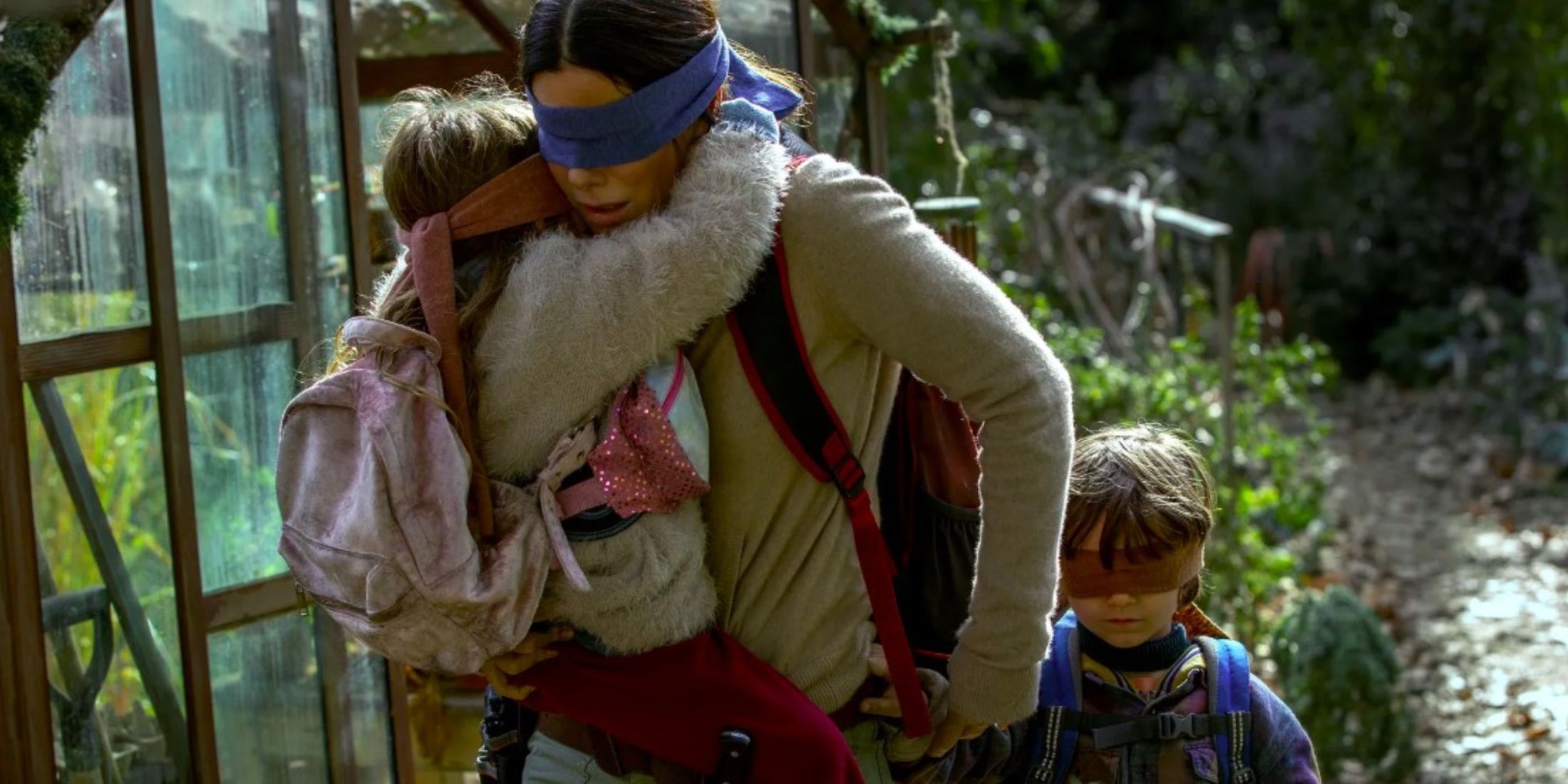 The main character with 2 children, all blindfolded.