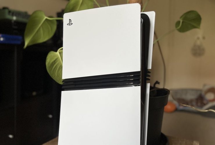 Top section of a PS5 Pro console in front of a houseplant