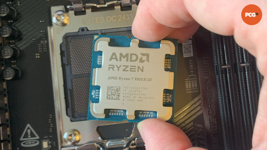 AMD Ryzen 7 9800X3D review: Gaming CPU held over AM5 motherboard socket.