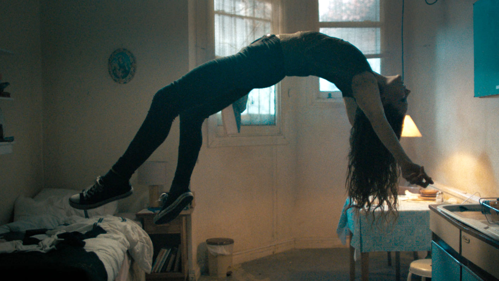 Morfydd Clark as Katie floating in the air during the horror movie, Saint Maud.