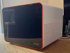 BenQ X3100i projector positioned on a wooden desk