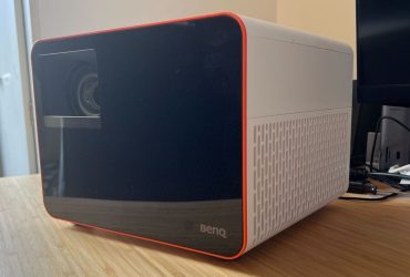 BenQ X3100i projector positioned on a wooden desk