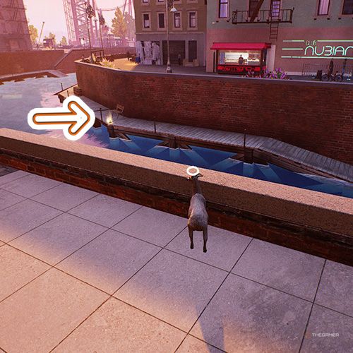 An orange arrow points the trophy that is on the dock near canal in Goat Simulator Remastered