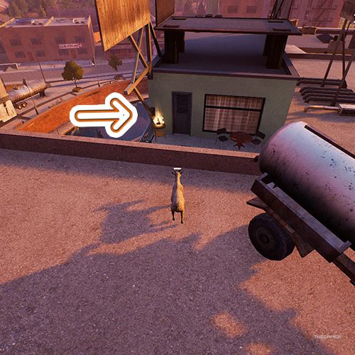 An orange arrow points the trophy that is on a green buildings's balcony in Goat Simulator Remastered