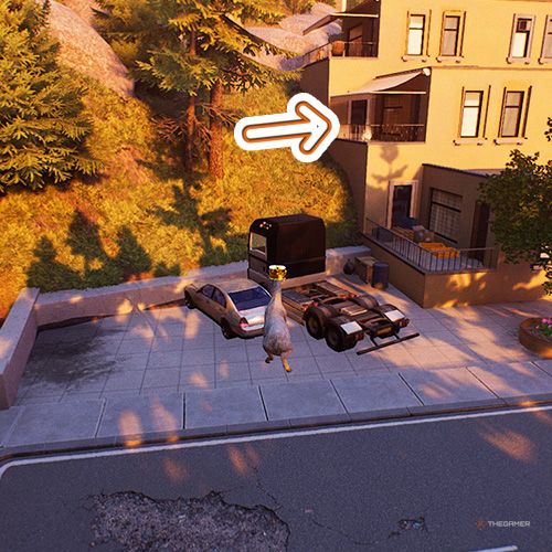 An orange arrow points the trophy that is on a balcony next to a grassy slope in Goat Simulator Remastered