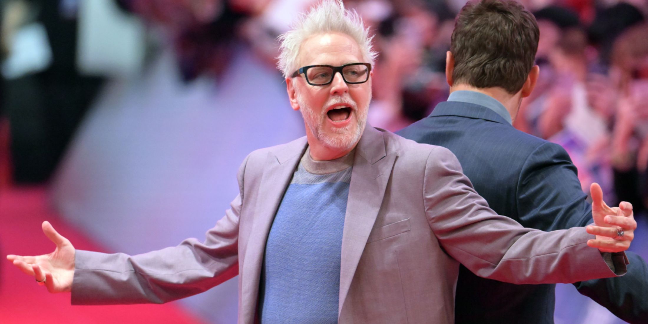 james gunn with his hands out and mouth open