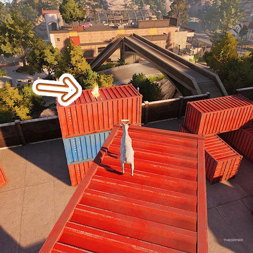 An orange arrow points the trophy that is on top of a red container in Goat Simulator Remastered