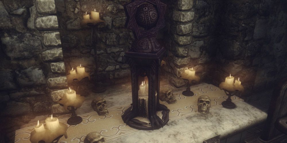 A statue surrounded by candles and skulls in Skyrim