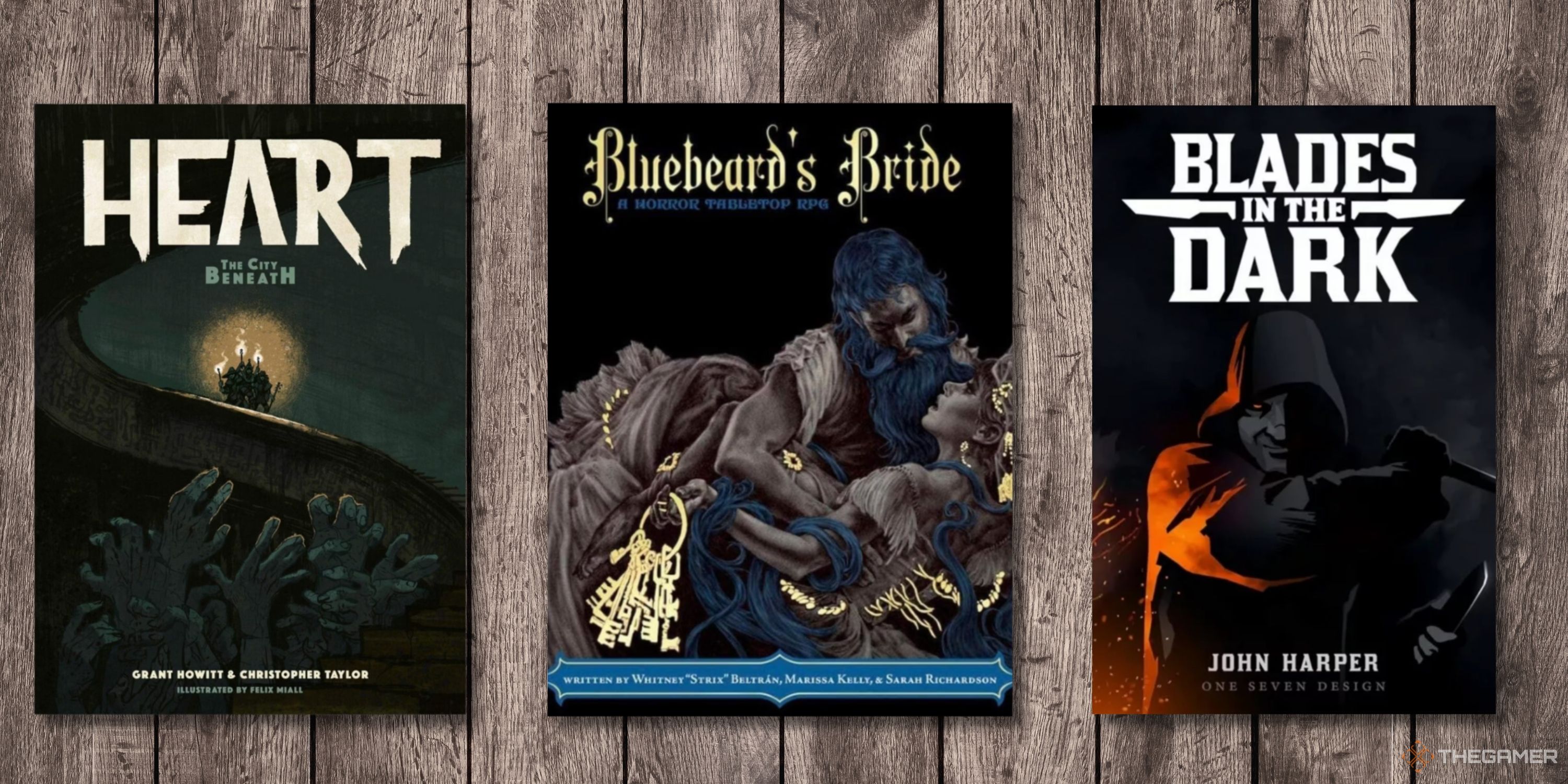 Three TTRPGs on a table - Heart, Bluebeards Bride, Blades in the Dark