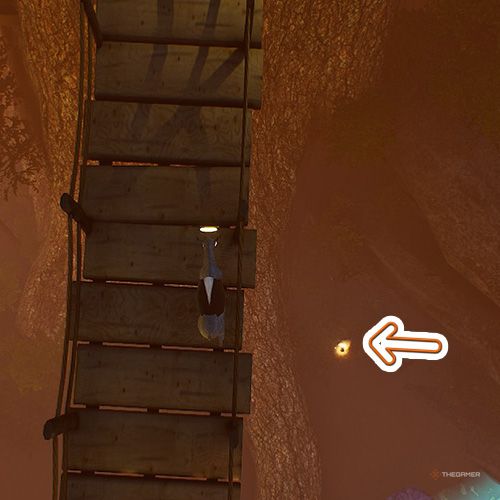 An orange arrow points the trophy that is beneath a wooden bridge in Goat Simulator Remastered