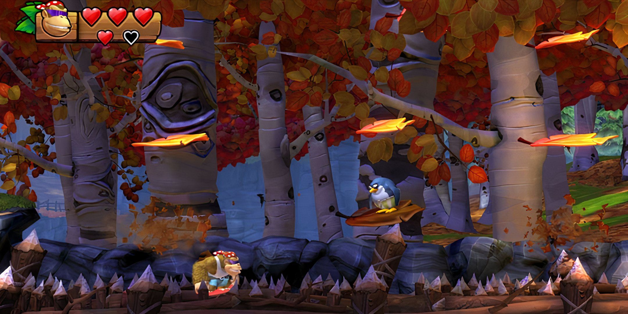 Funky Kong and a penguin in an autumnal forest in Donkey Kong Country: Tropical Freeze.