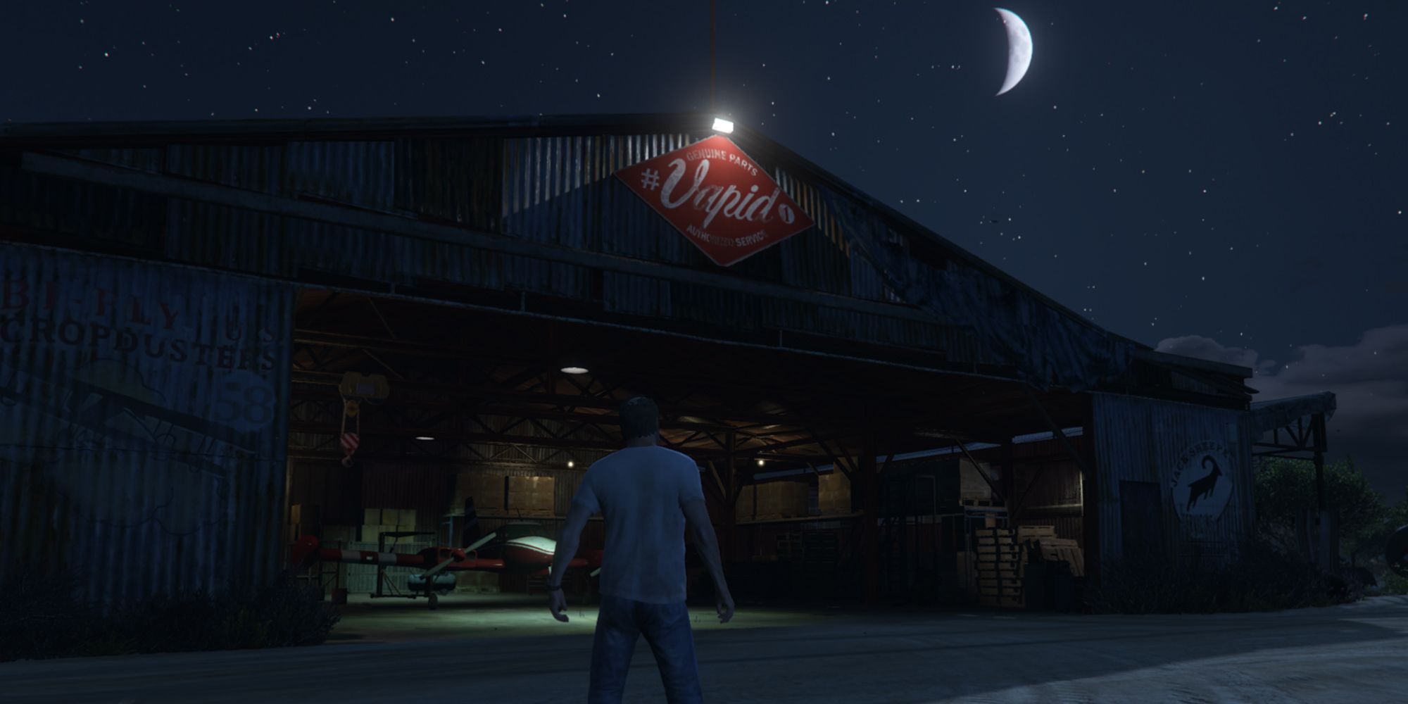 Trevor standing near McKenzie Field Hangar in Grand Theft Auto V.