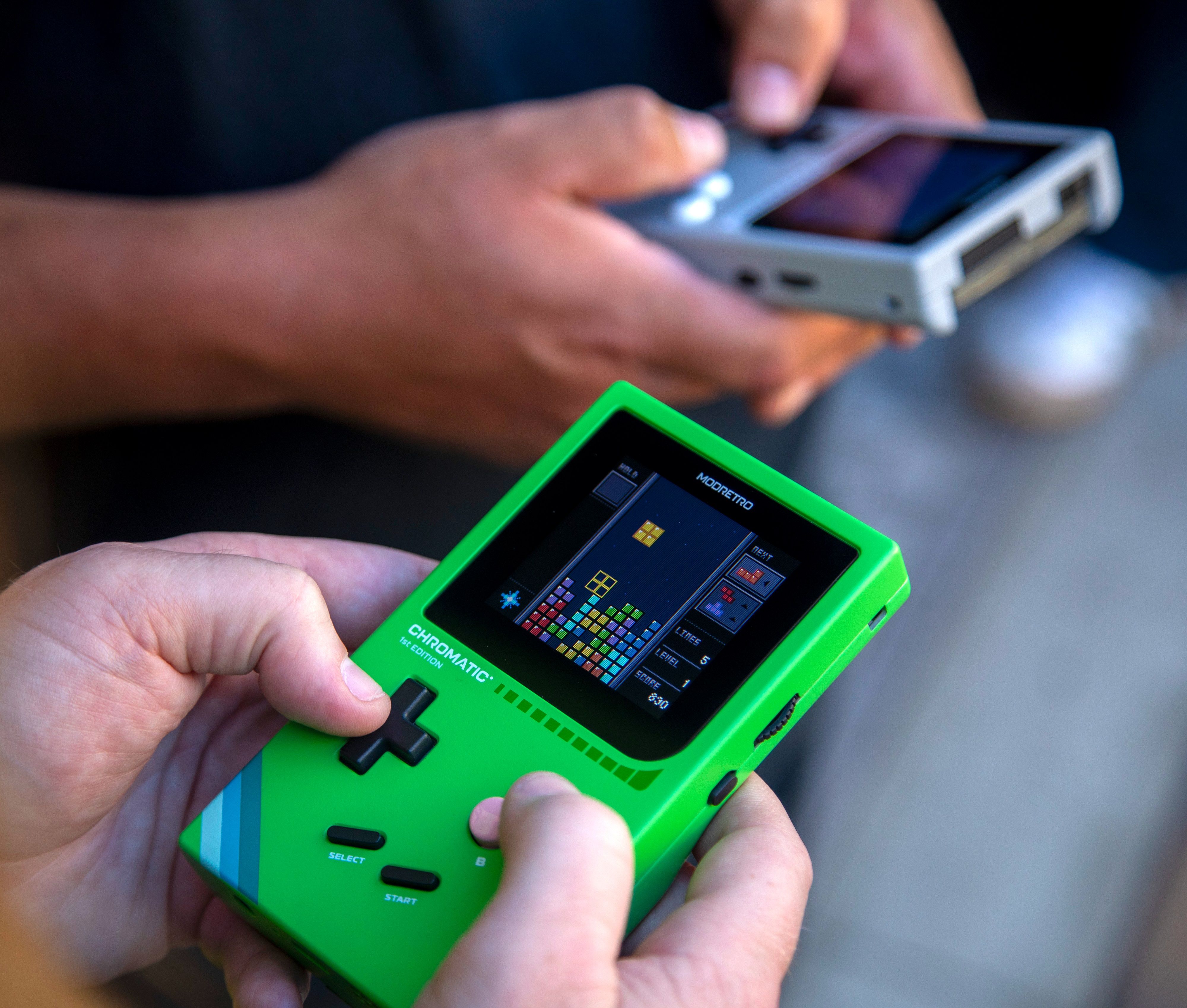 Two people playing a Chromatic Handheld.