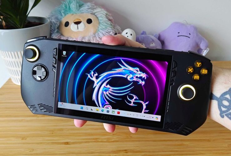 Hand holding MSI Claw handheld with logo wallpaper on screen