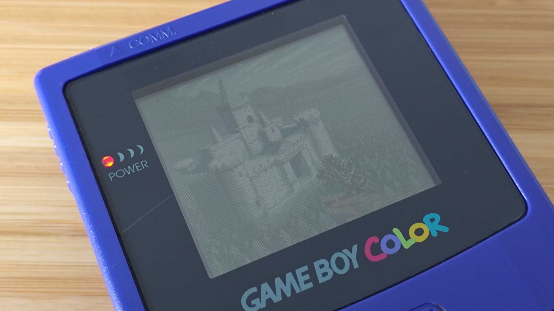 Original Game Boy Color with closeup of Zelda: Oracle of Seasons intro with Link on horse in front of castle