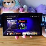 Hand holding PlayStation Portal with PS Plus games library on screen