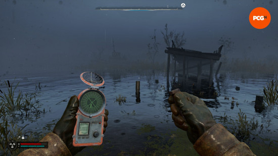 Stalker 2 review: a first person view of someone holding a strange device in one hand, and a large metal bolt in the other.