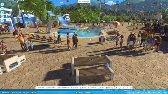 Planet Coaster 2 screenshot showing a guests meandering around a large plaza with a swimming pool and slide at its centre.