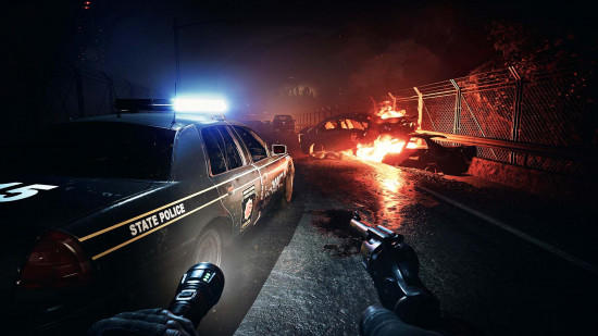 No More Room in Hell 2 Reinforcement update: A first-person screenshot of a player holding a revolver and flashlight while walking down a chaotic highway with a police car on the left and a flaming car on the right.