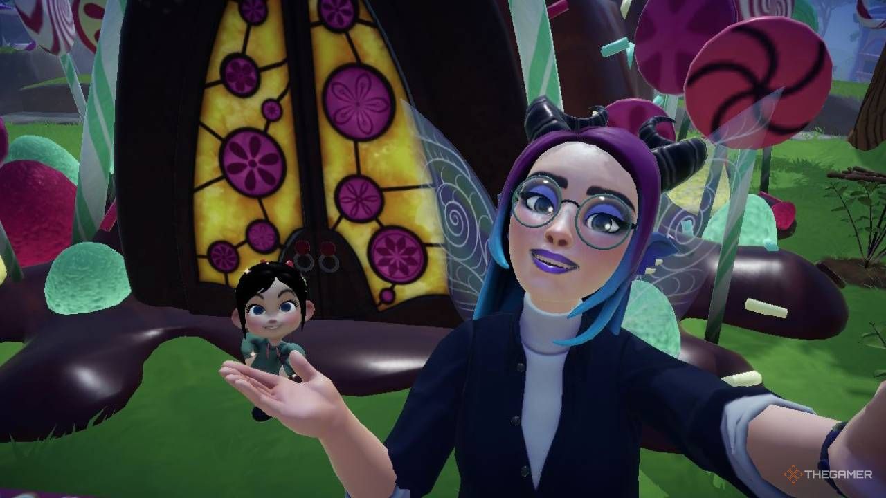 Disney Dreamlight Valley avatar taking a selfie with Vanellope. Vanellope's house can be seen in the background.