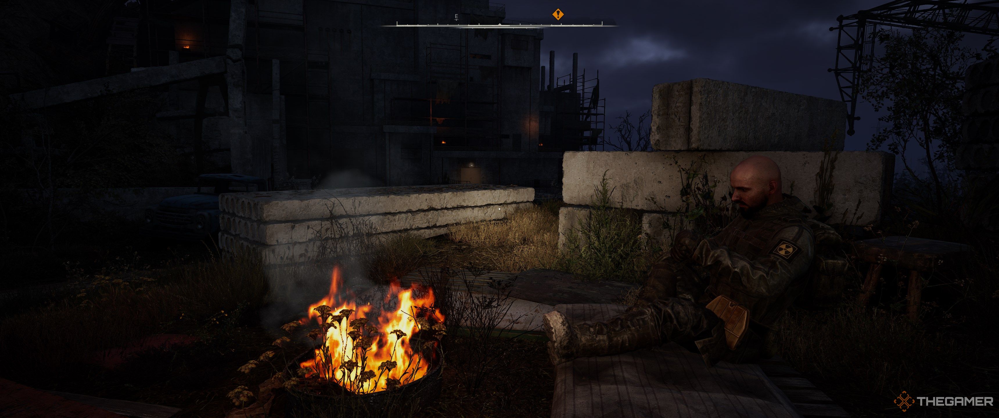 A stalker sat next to a campfire in Stalker 2: Heart of Chornobyl.