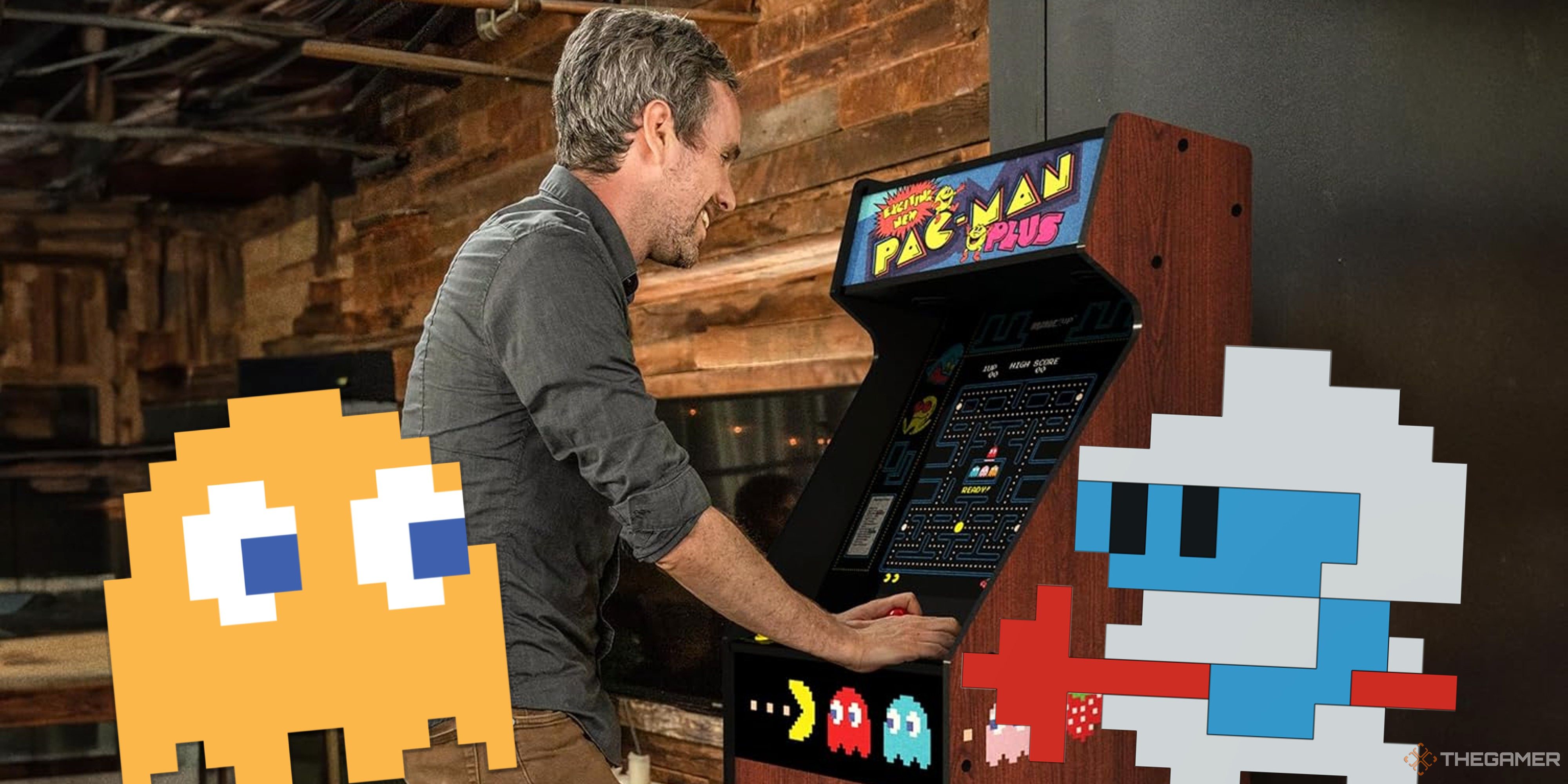 man playing arcade1up pac-man machine with pac-man ghost and dig dug sprites in front of him