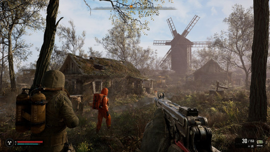 Stalker 2 multiplayer: two people in hazmat suits wander around an abandonded village.