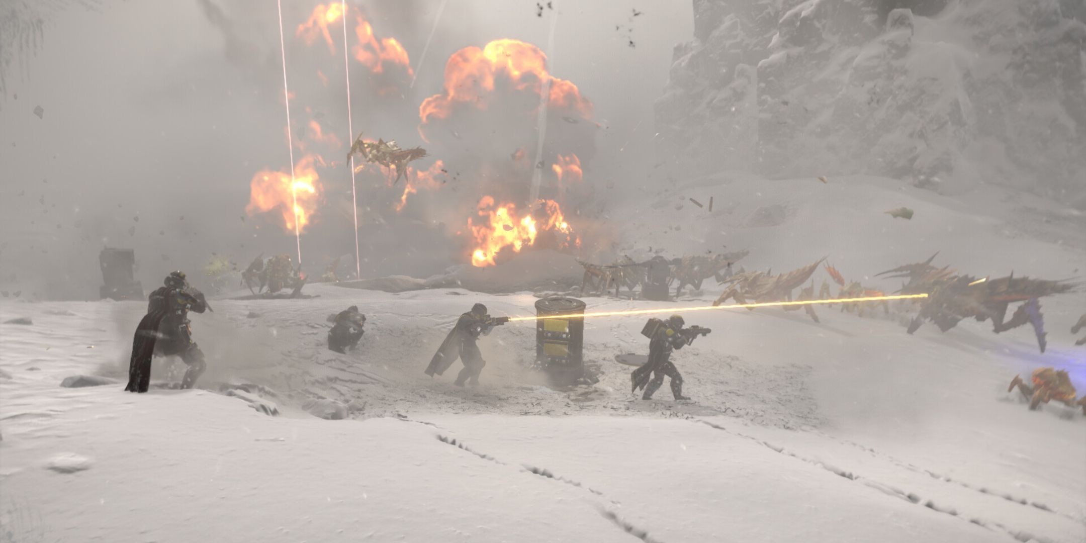 A squad of Helldivers have posted up in the snow, firing at a group of encroaching bugs in Helldivers 2.