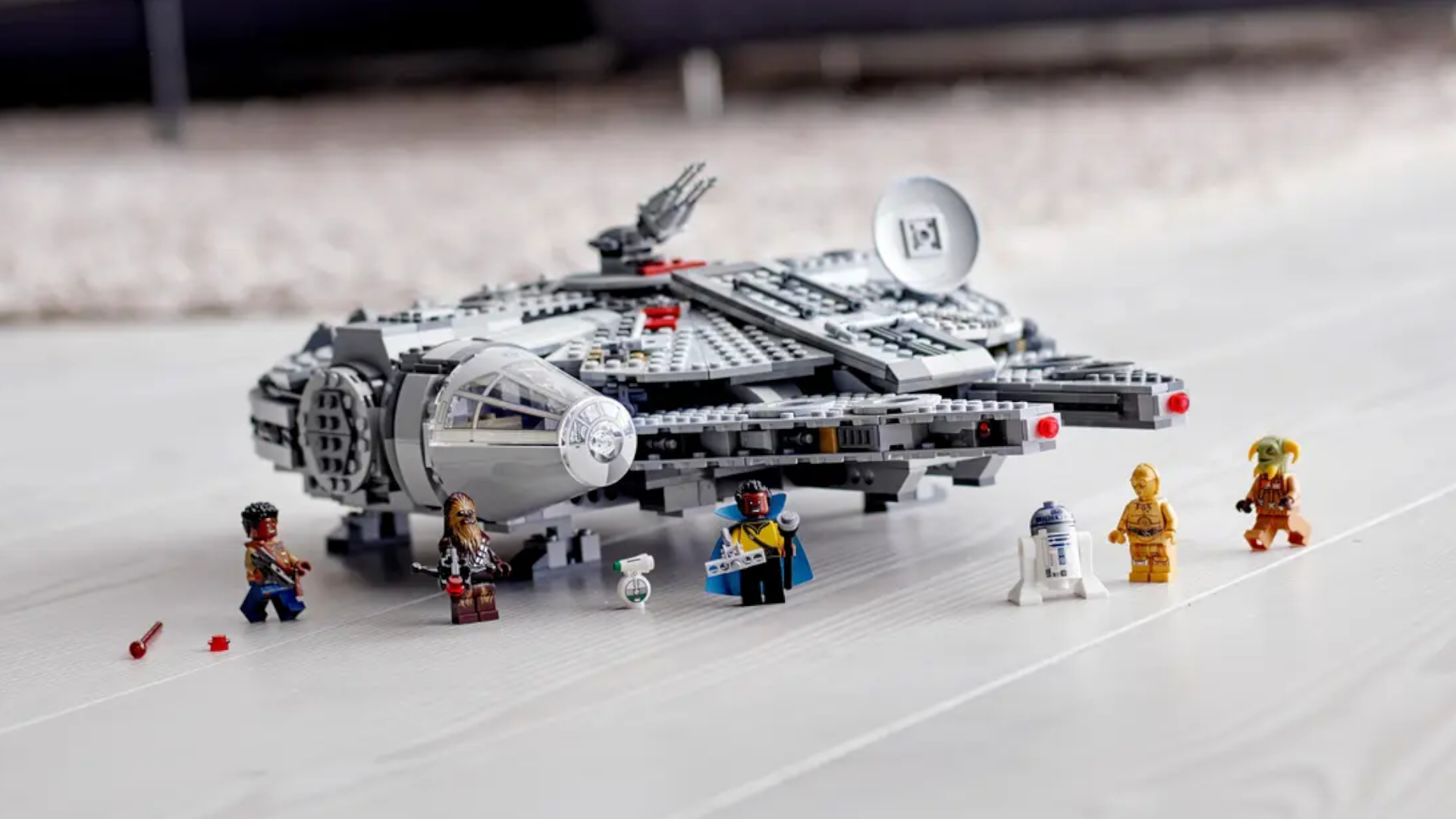 Lego Millennium Falcon and minifigures on a wooden floor