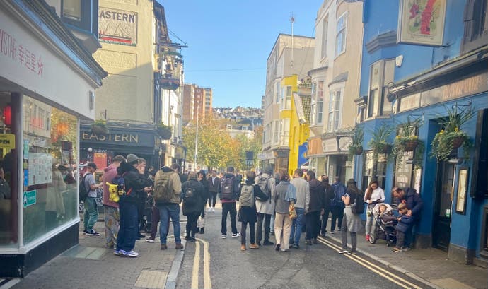 Brighton Pokémon Go players crowd a small city side street.