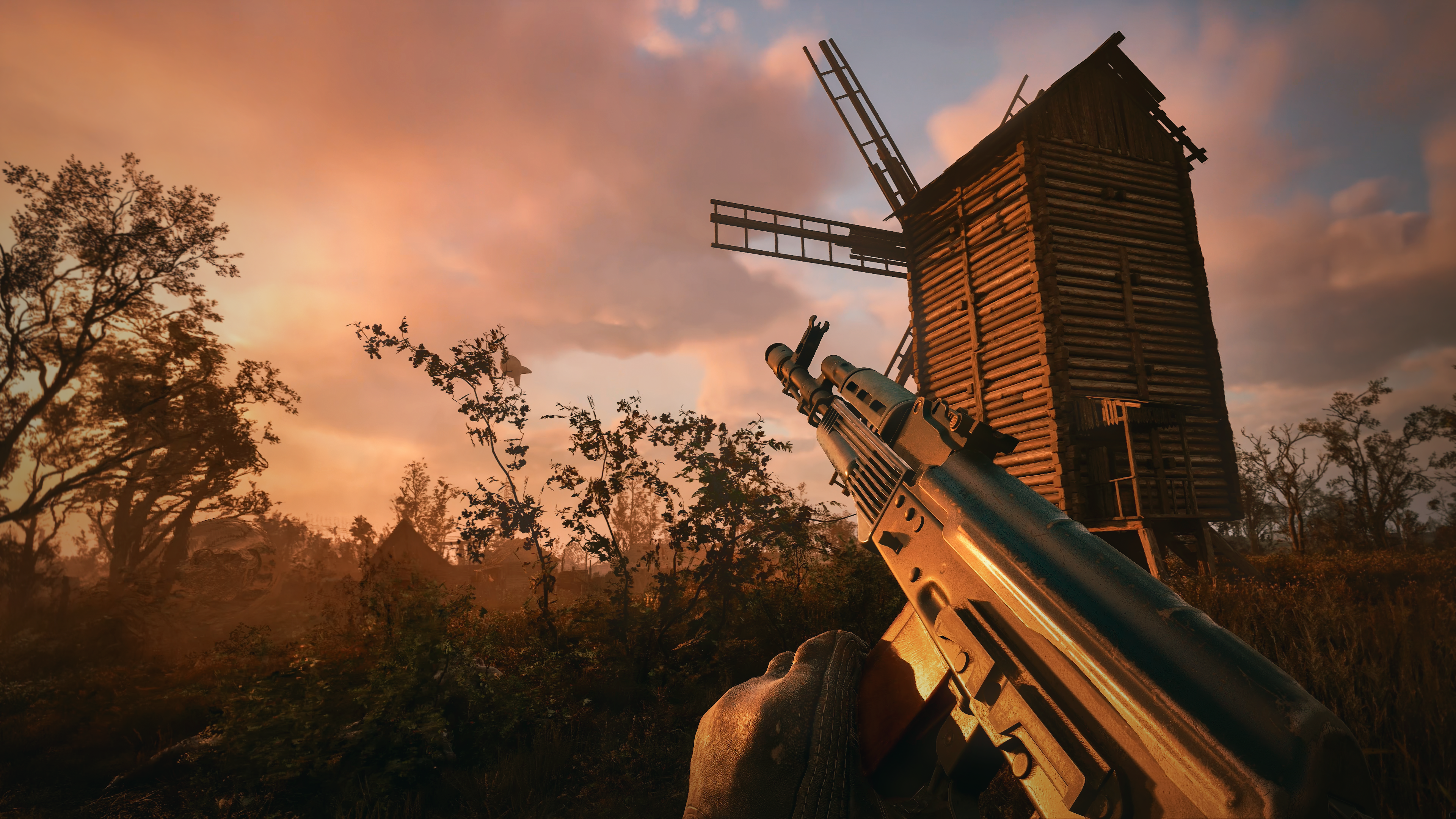 The player approaches a windmill while reloading their weapon in Stalker 2. 