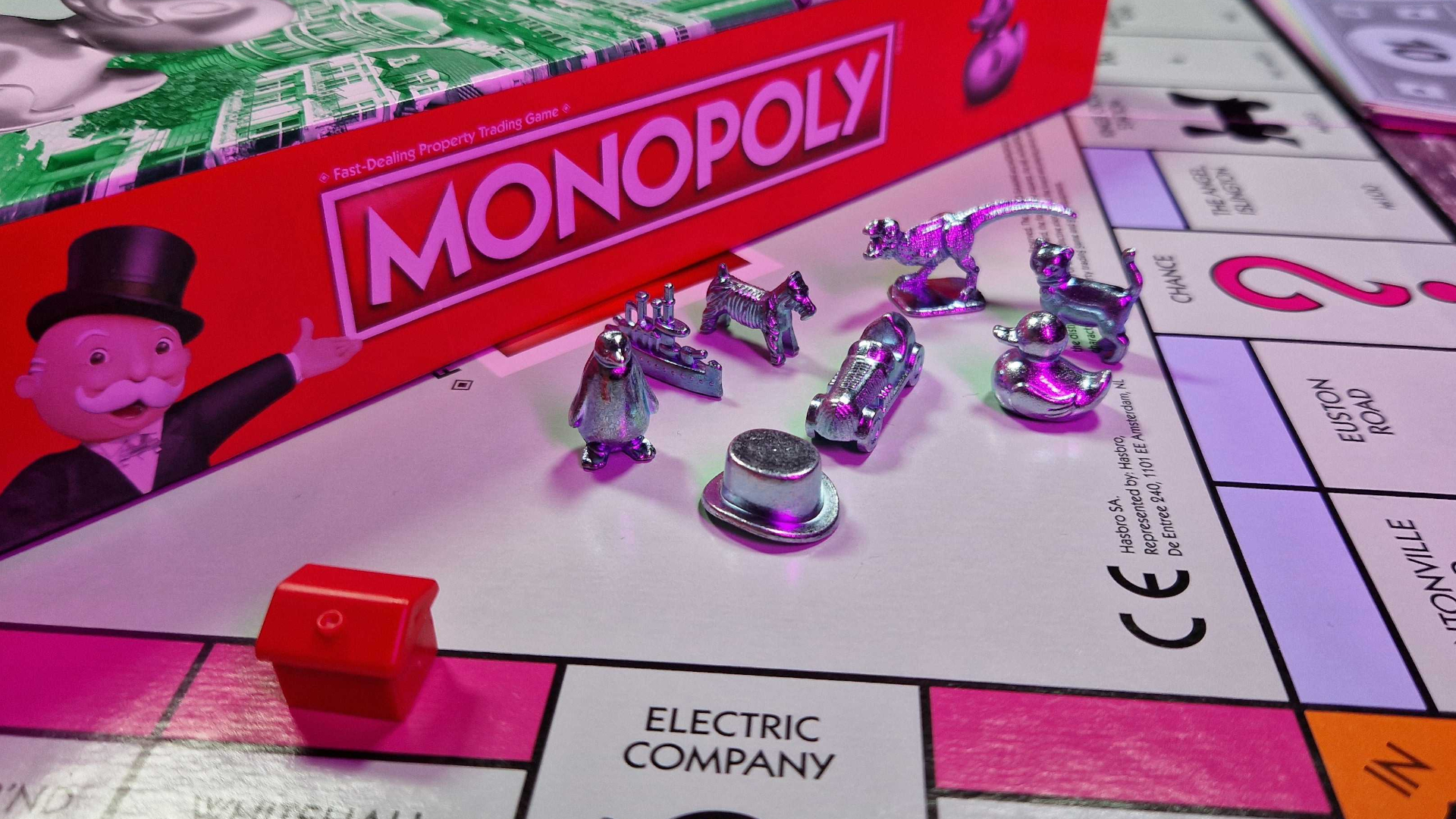 Monopoly playable tokens on a board, with the box behind them