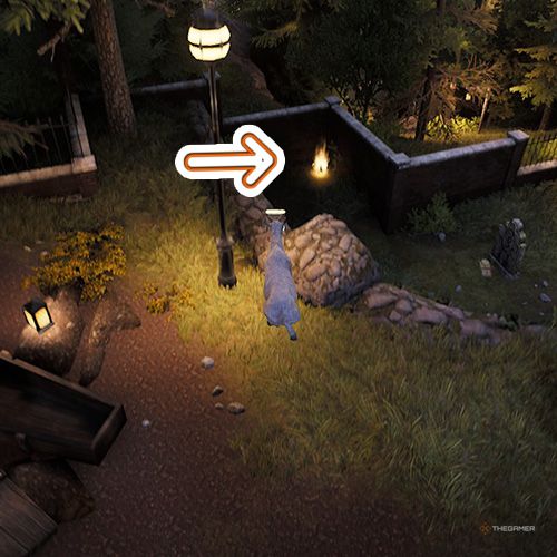 An orange arrow points the trophy that is near the street lamp inside the graveyard in Goat Simulator Remastered