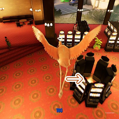 An orange arrow points the trophy that is surrounded by slot machines in Goat Simulator Remastered