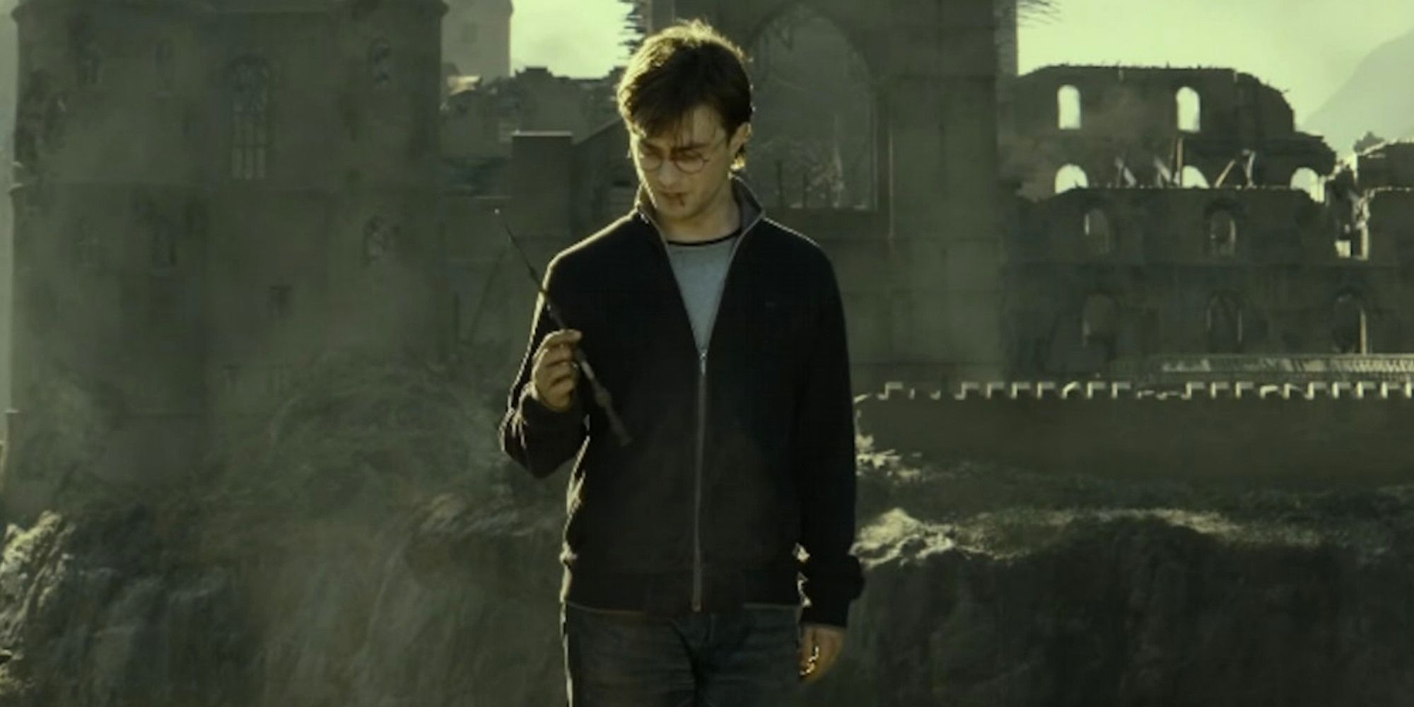 Harry Potter holds the elder wand outside of Hogwarts