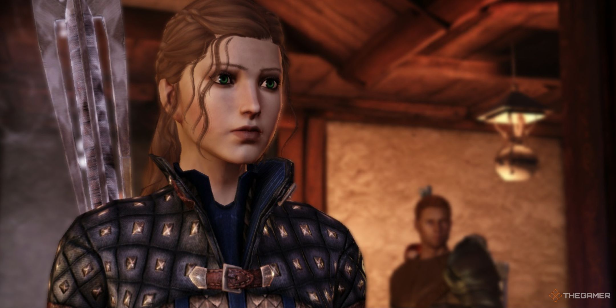 The Hero of Ferelden in Dragon Age: Origins. She has brown hair and wears blue armour with a mage staff on her back