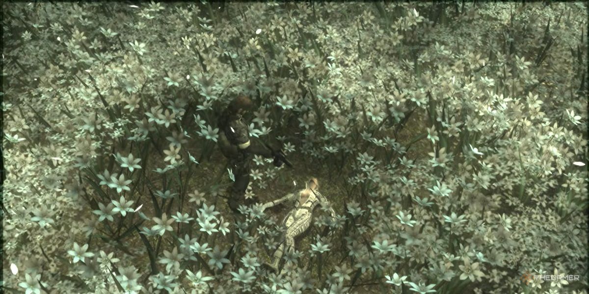 Snake points a gun at the Boss in a field of white flowers in Metal Gear Solid 3.