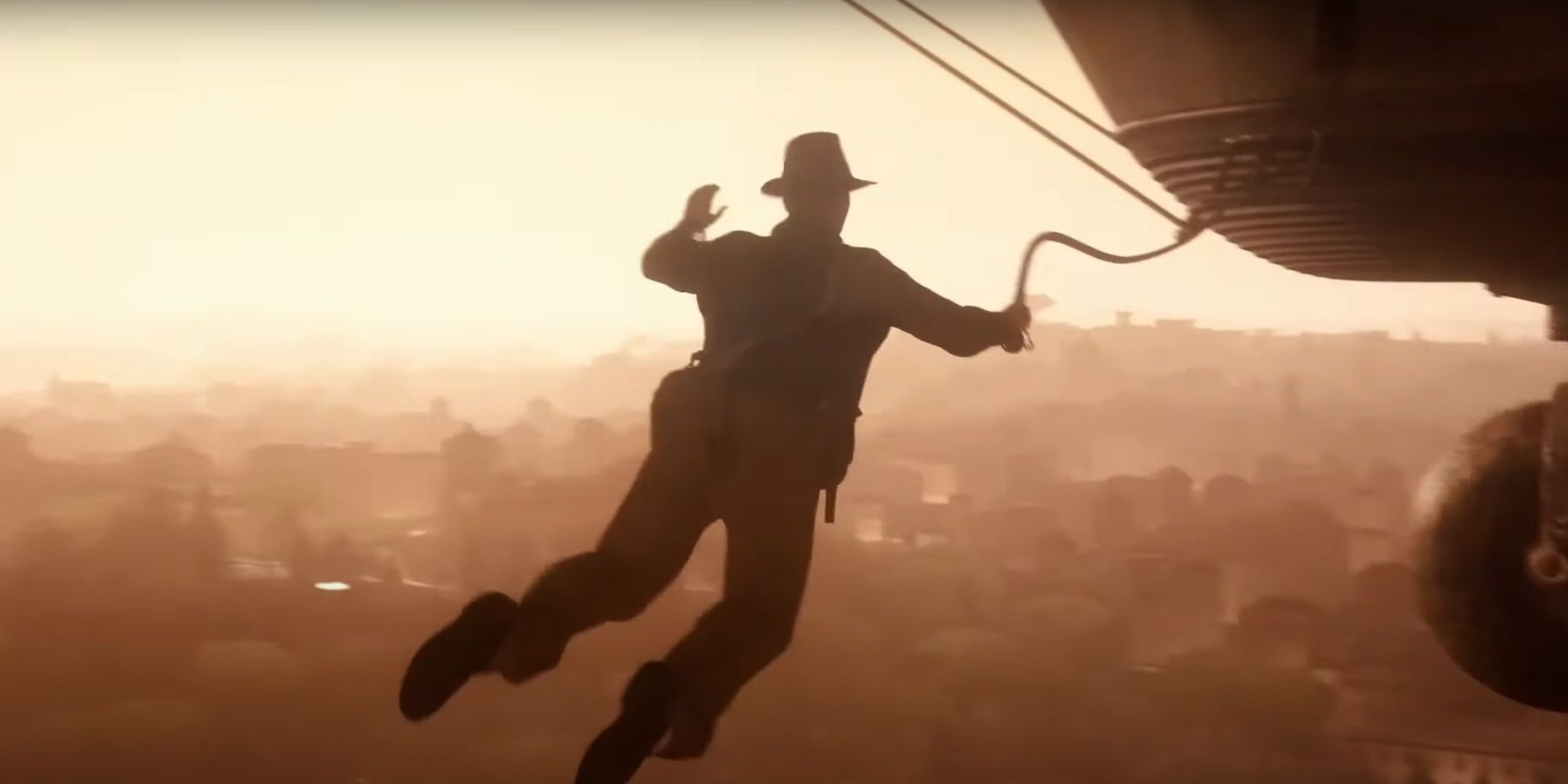 Indy's silhouette in the third-person as he lunges and grapples onto a hot air balloon. 