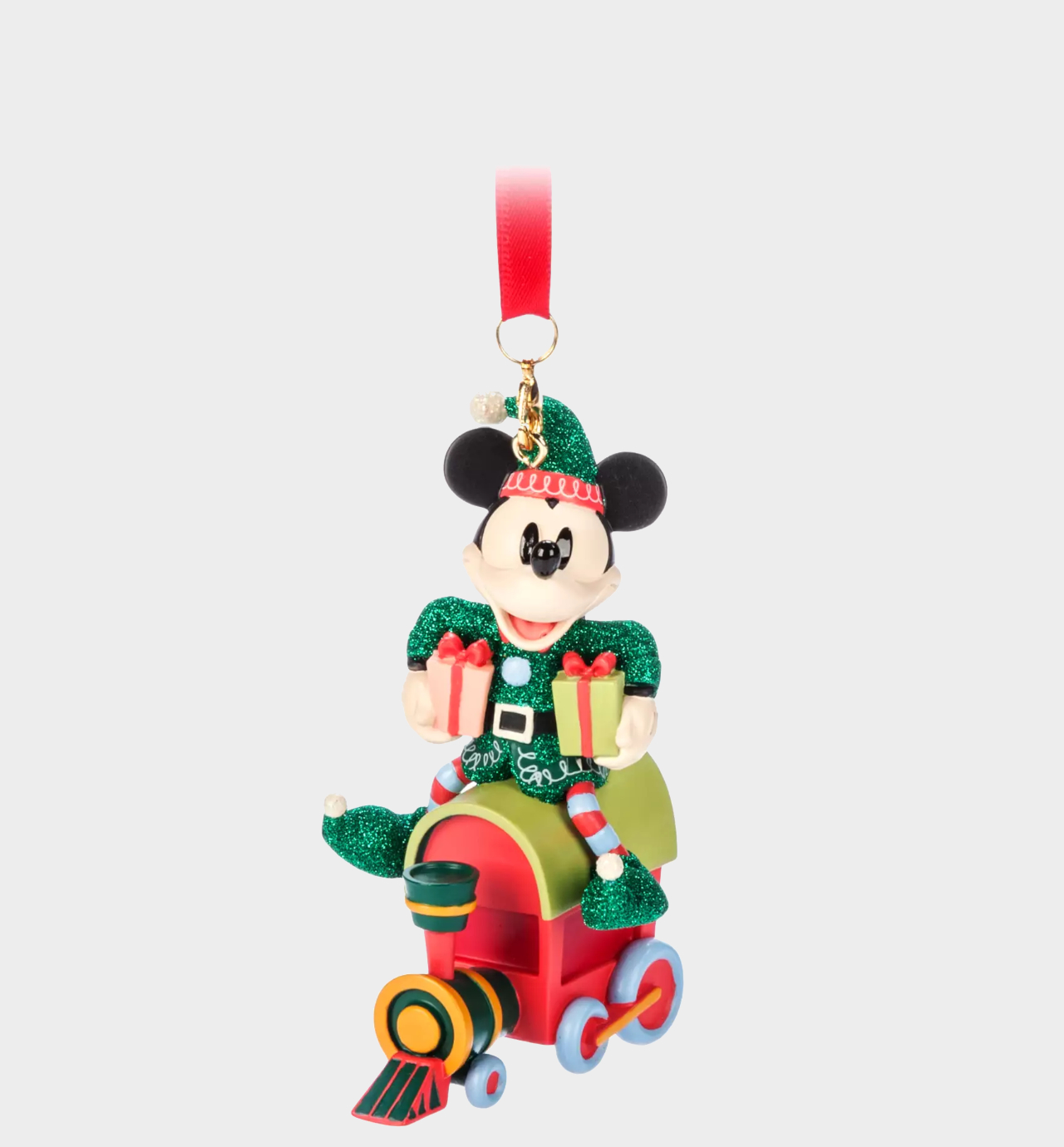 Disney ornament of Mickey Mouse on a train, holding presents under his arms