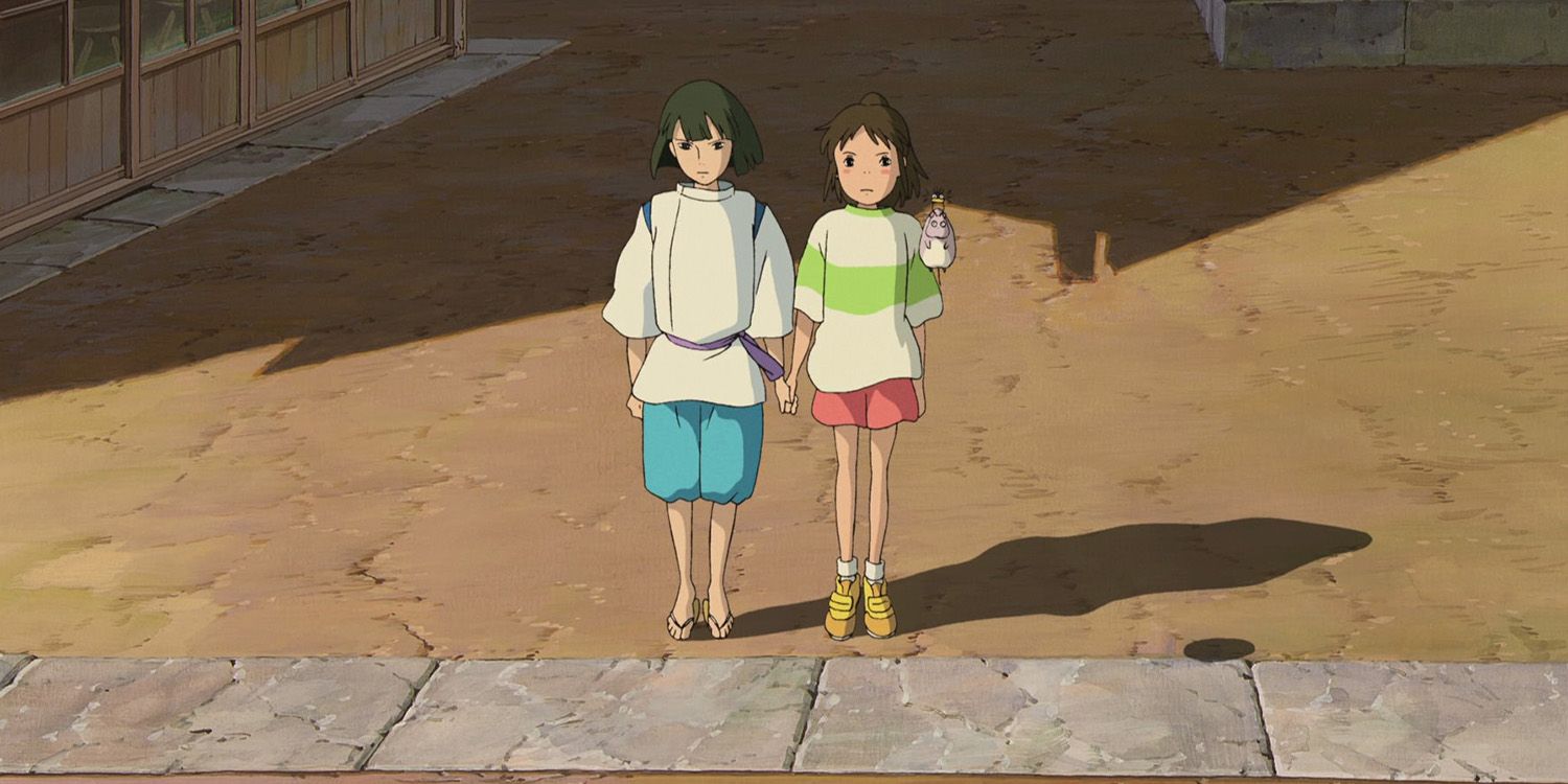 Haku and Chihiro hold hands in Spirited Away.