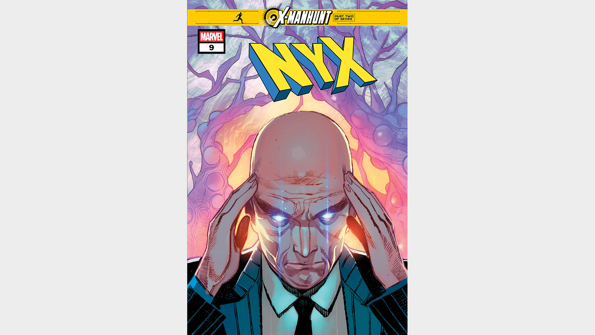 Charles Xavier holds his head while his eyes glow.