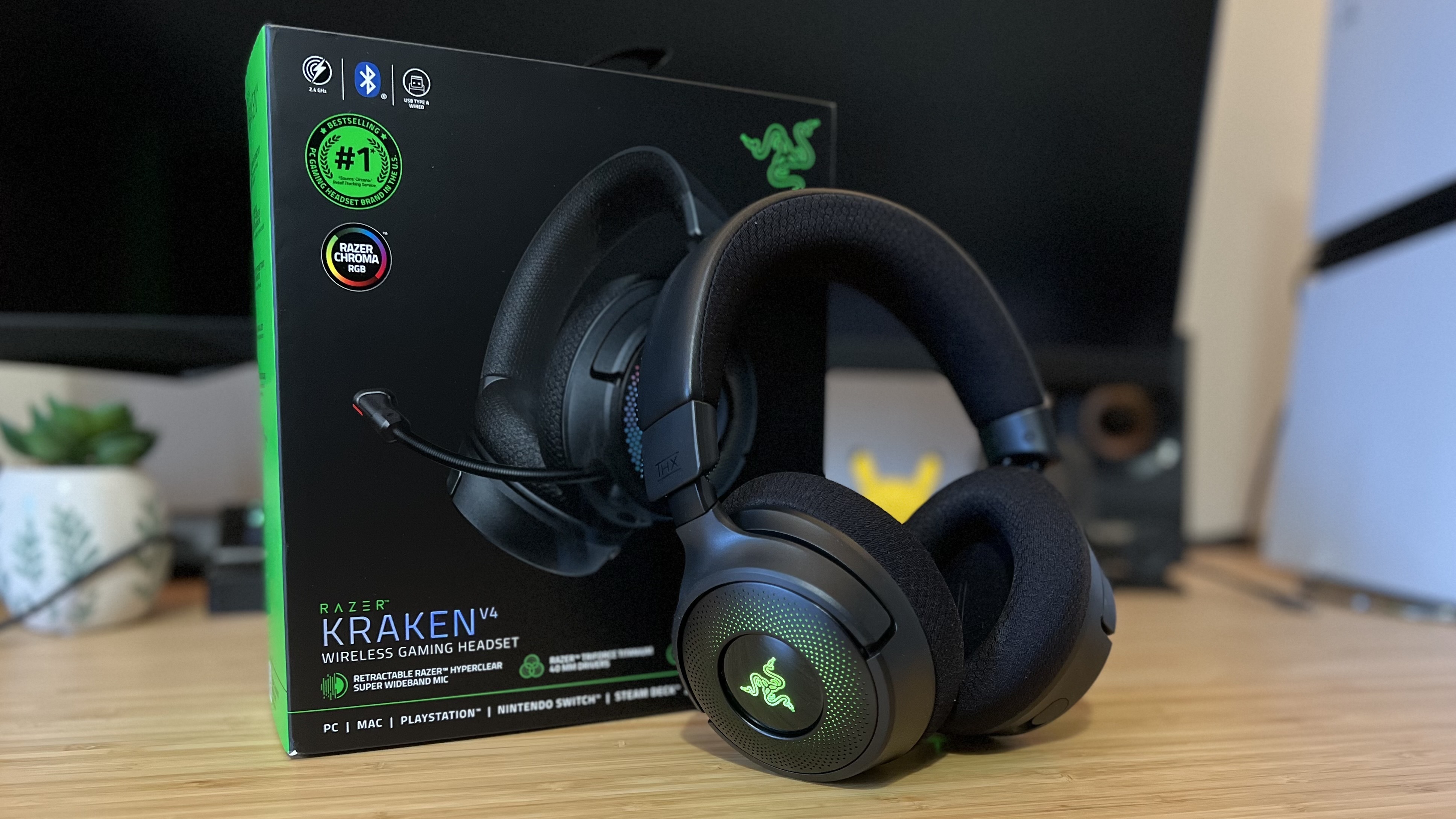 Razer Kraken V4 headset leaning against box on a wooden desk